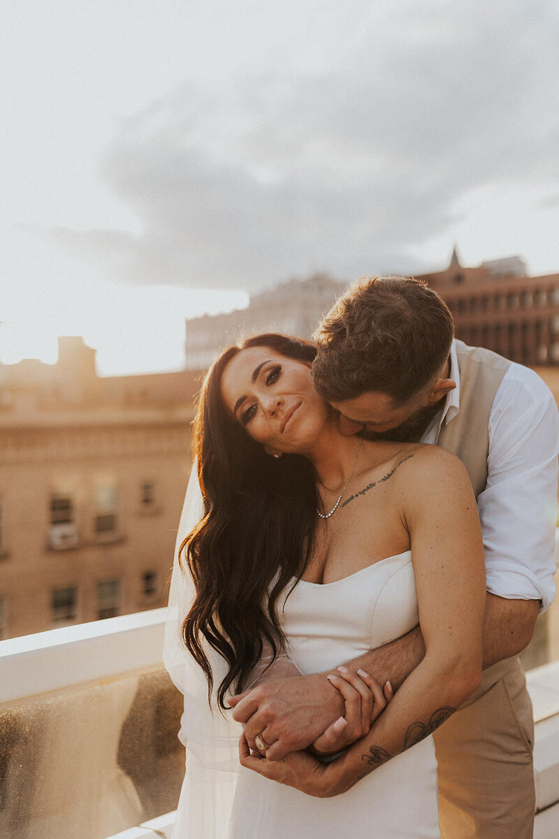 bride and groom embracing on rooftop