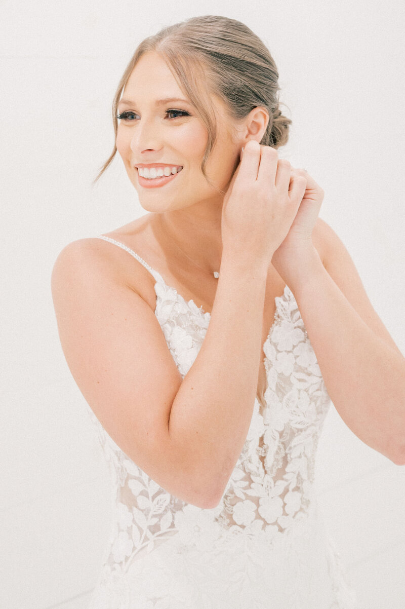 Dallas-Fort Worth Wedding Photographer | DFW Photographer Rae De Lain Weddings Light and Airy | Bride putting on earring The Rosemary Venue
