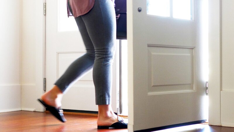 Woman stepping out door to  begin her retirement journey