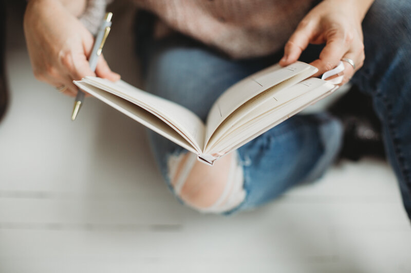 An open notebook and a pen holding in  hands