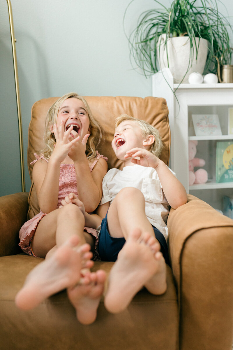 Couple walking along Tampa marina at sunset while holding hands and pregnant mother holds baby bump in stunning white dress