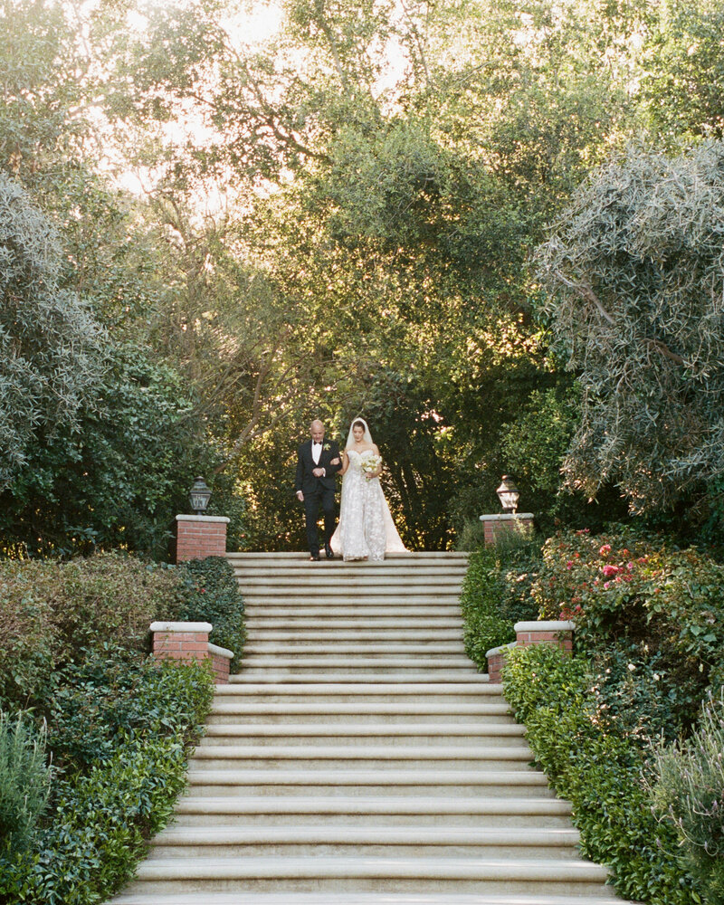 Bride and groom in car kissing with white flowers in Los Angeles