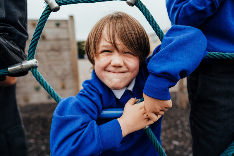 Boy climbing on ropes on playground - St Johns COE school, Hampshire