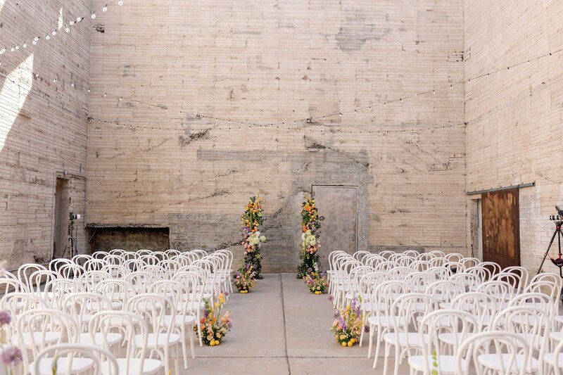 Wedding ceremony with colorful florals setup in industrial space