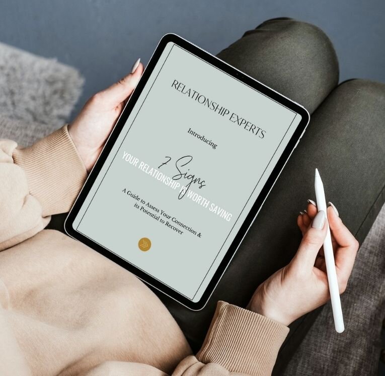 Person holding a tablet displaying the free guide “7 Signs Your Relationship Is Worth Saving” by Relationship Experts, designed to help couples assess their connection and discover if their relationship can heal and grow.