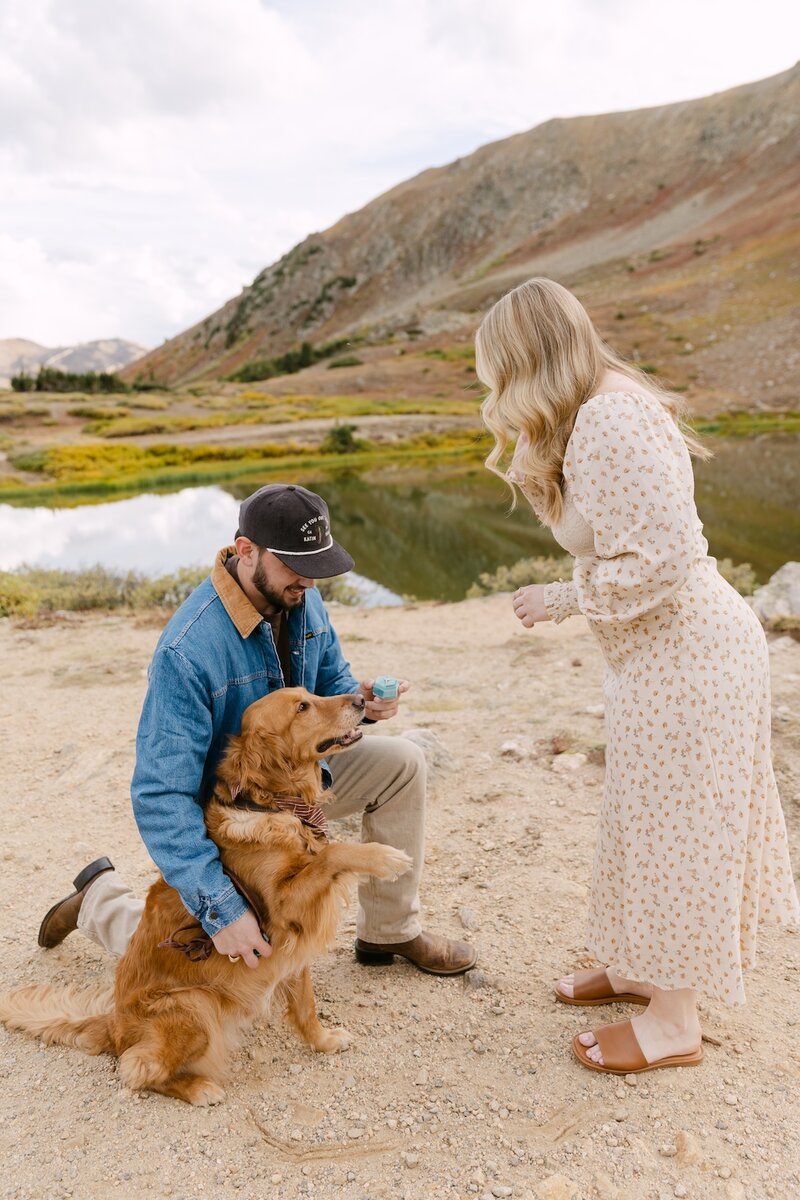 Intimate Colorado micro wedding ceremony with bride and groom and officiant on a rocky overlook with snowcapped mountains in the distance – micro wedding photographer in Colorado