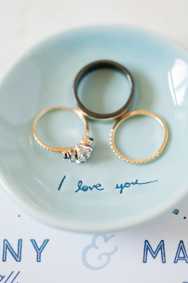close up of wedding rings in a ring dish