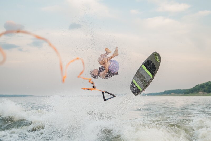 a boy flipping off of a wake board at Saylorville Lake