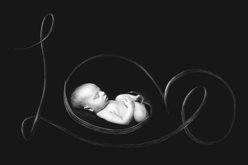 Artistic newborn portrait featuring the word 'Love' beautifully drawn around the baby, captured in Overland Park, Kansas. A striking black-and-white setup perfect for families seeking creative and meaningful newborn photography in the Kansas City area