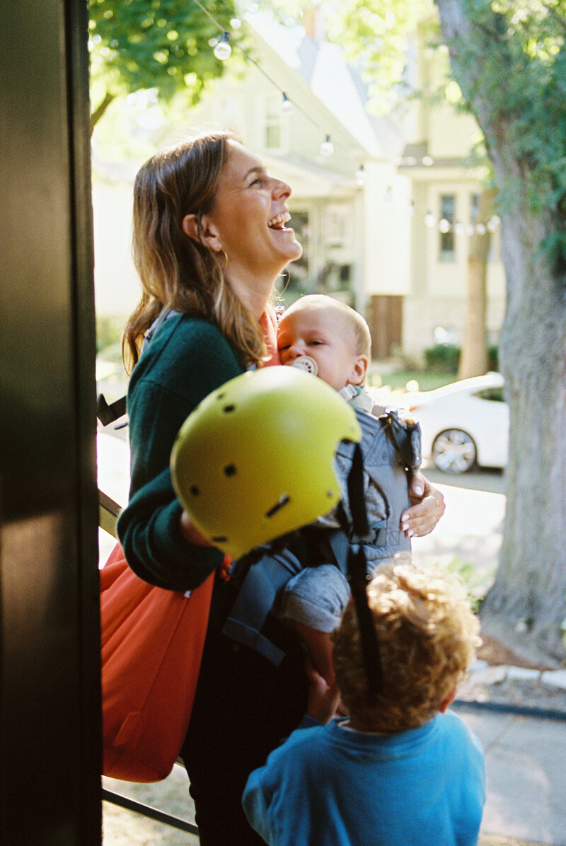 Family laughing during lifestyle photography session on film.