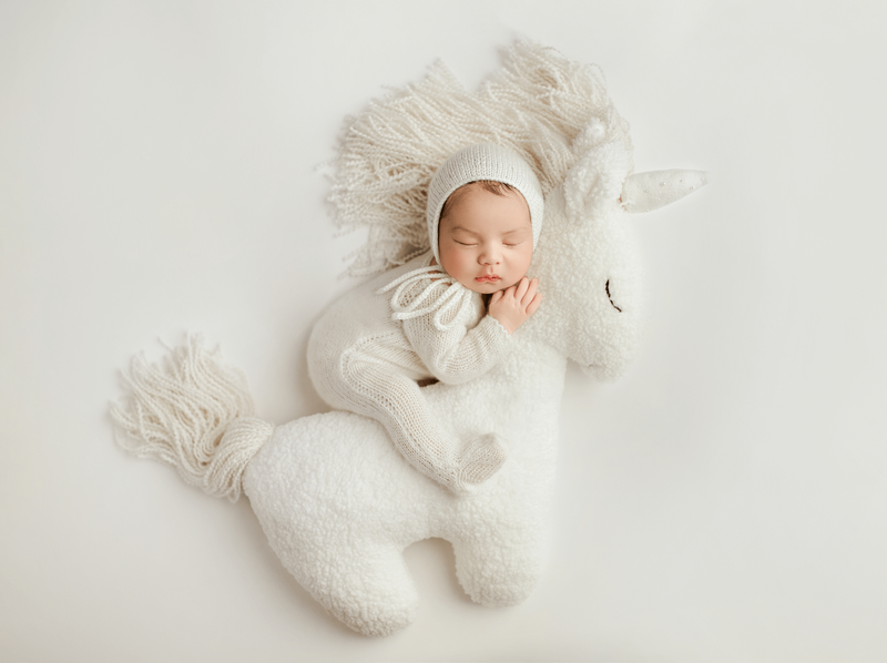 Airy newborn photograph with gentle highlights, minimal styling, and soft neutrals for a modern fine-art look