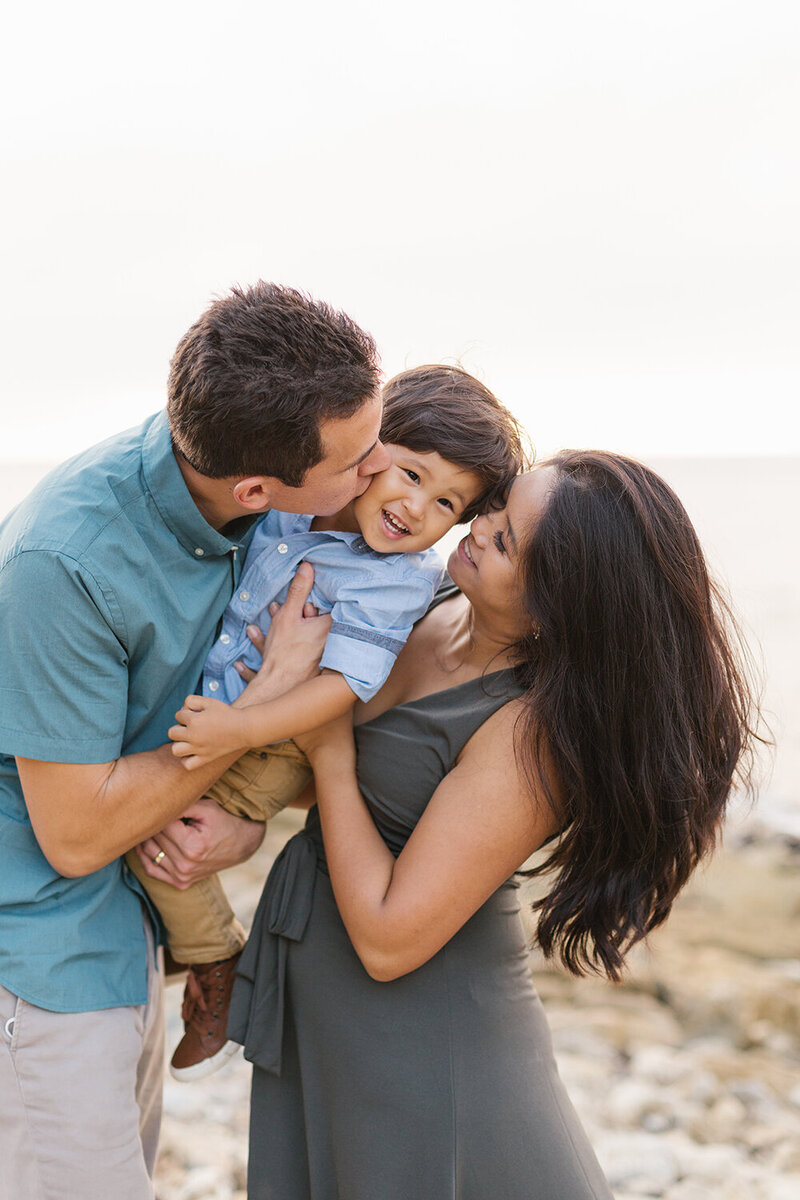 parents hold giggling son for palos verdes family photos