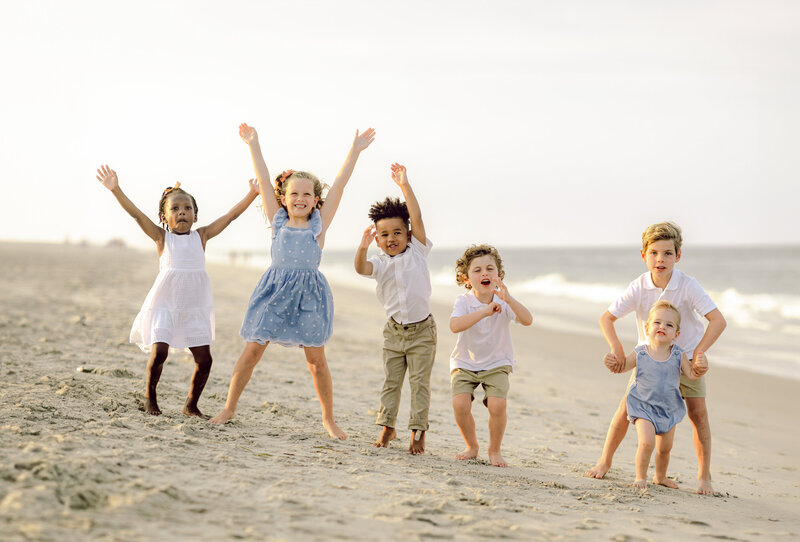 a photo of the kids playing on the beach of the OBX