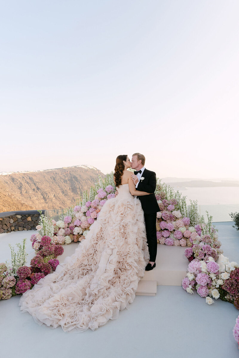 Couple sharing a kiss after their wedding ceremony at Aenaon Villas in Santorini.