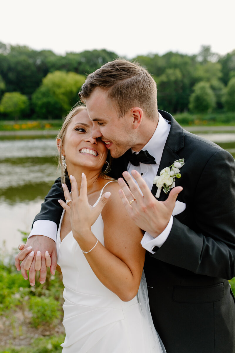 Bride and groom show off their wedding rings