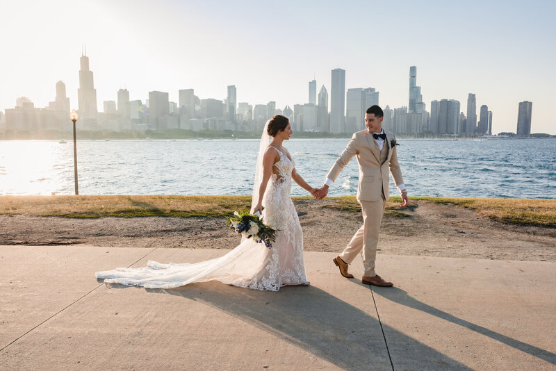 Bride and groom walk along the lake front at the Adler Planetarium in Chicago, IL