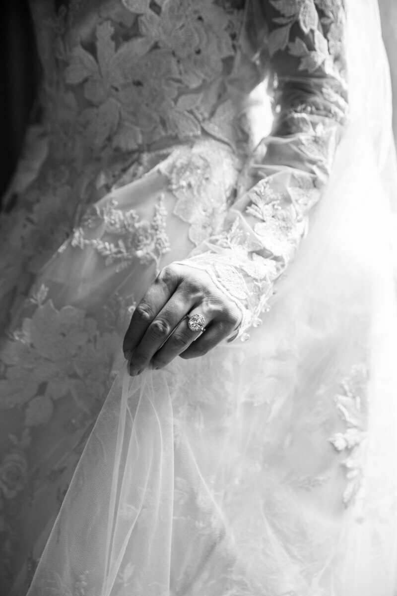 bride holds her veil while wearing her monique lhuillier long sleeve wedding dress