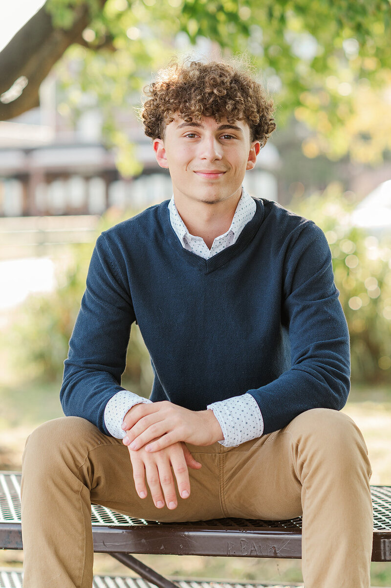 In your boy, sitting on a picnic table with a blue sweater and undershirt at John Wright restaurant by Lancaster, photographer