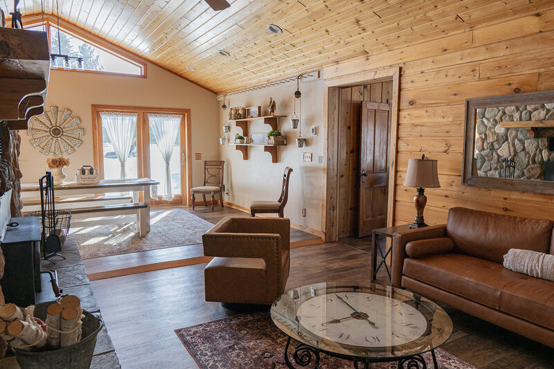 A living area with vaulted ceilings and patio doors with a lot of natural light.