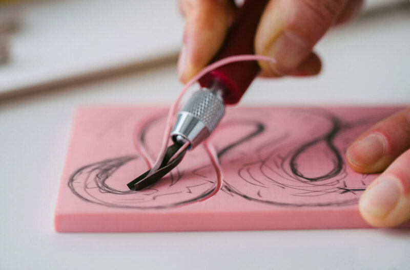 Image shows a close up photograph of a rubber block being carved by Skye McNeill. Sign up for the education email list to receive details about upcoming classes and workshops.