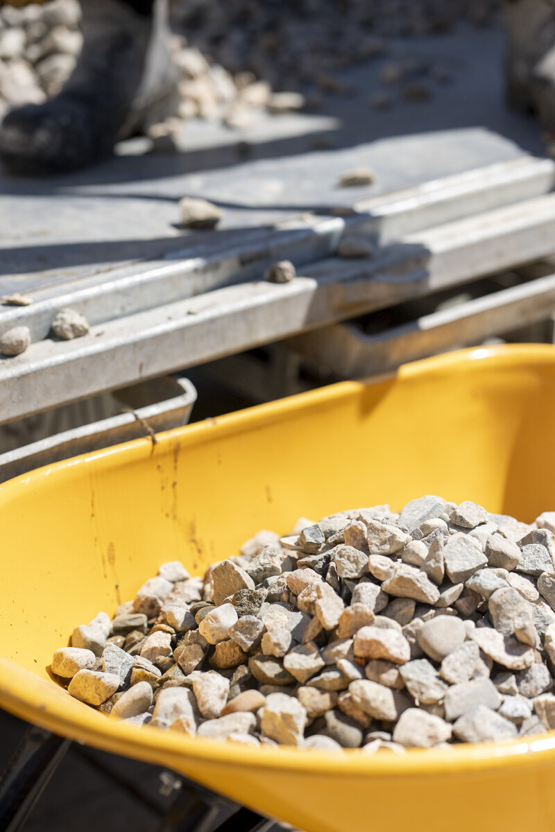 Filling wheelbarrow with rock