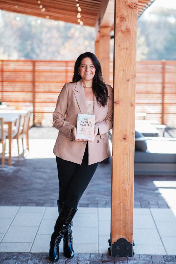 anxiety healer Allison Seponara leaning against a cedar column