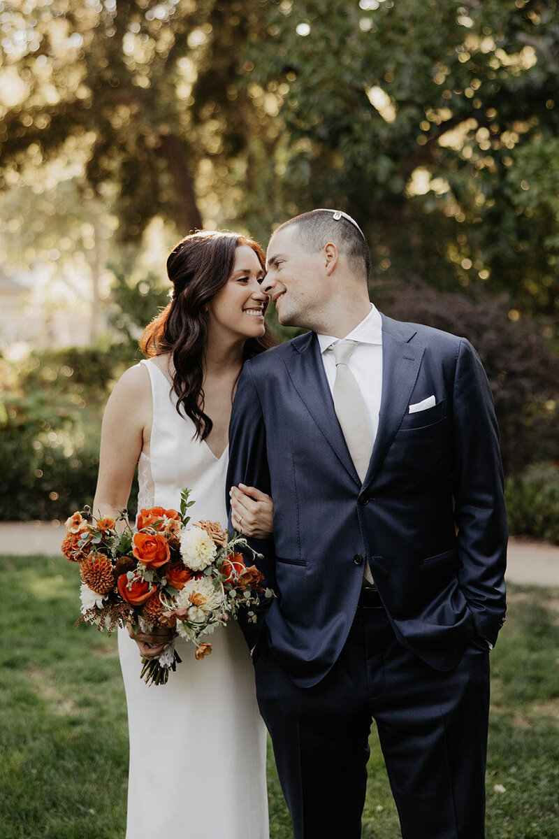 Couple smiling and walking with colorful wedding bouquet