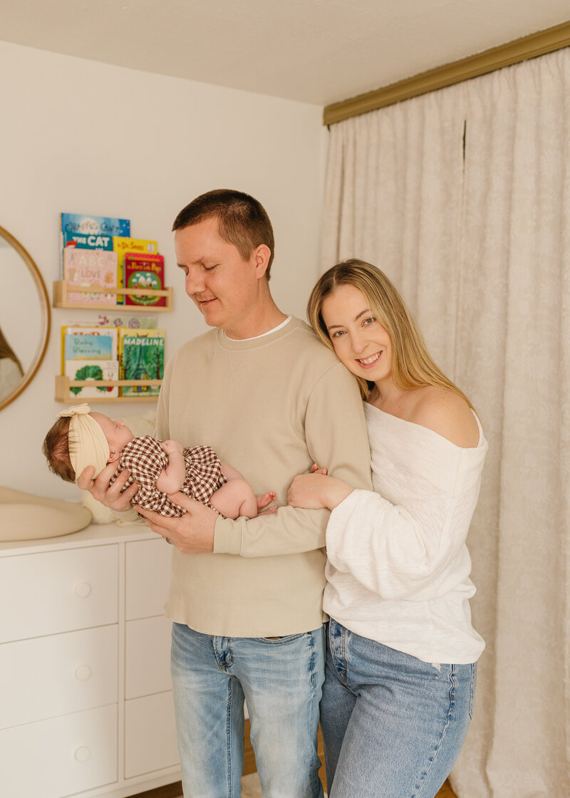 paremnts holding new born girl in nursery 