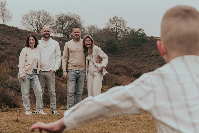 een kind loop vol vreugde op zijn ouders en oom en tante af 