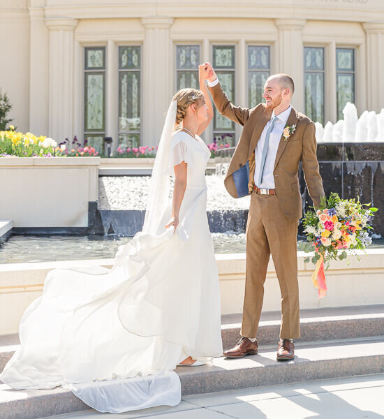 Salt Lake photography of a bride and groom dancing in front of the black fountain at the payson temple in the spring
