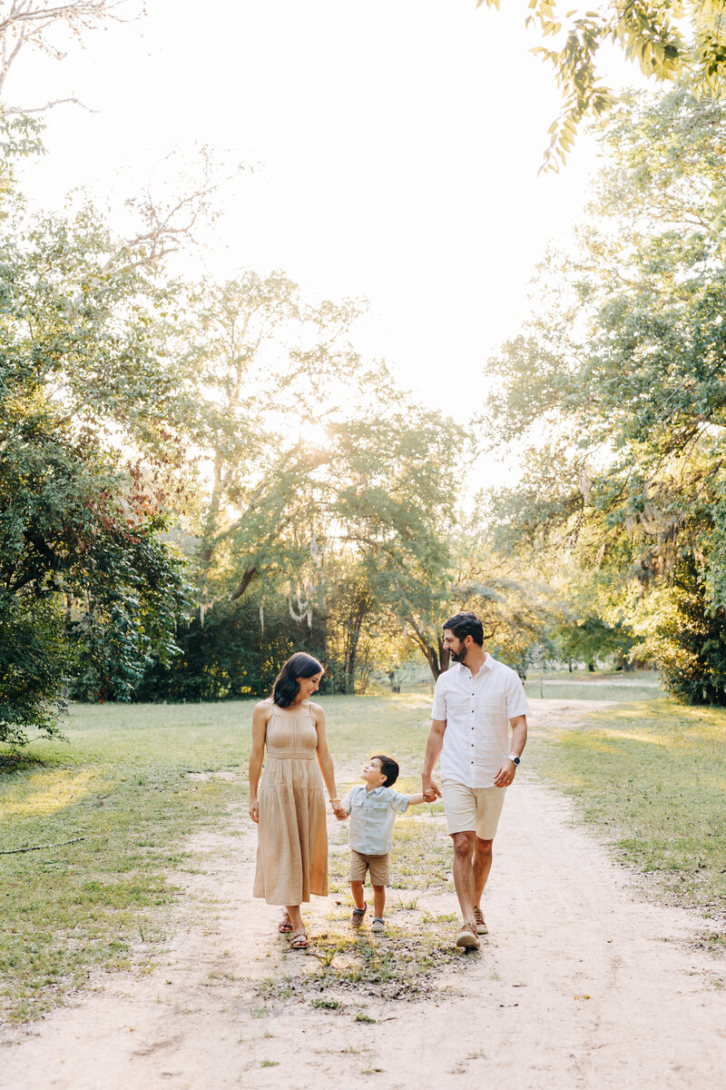 famly of 3 walking during a family photography session in Houston, Texas