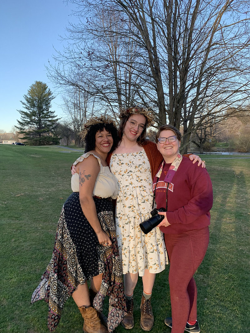 A Virginia elopement photographer stands next to an elopement couple near Duck Pond in Blacksburg, Virginia. The three smile widely for a photo at the conclusion of their elopement day.