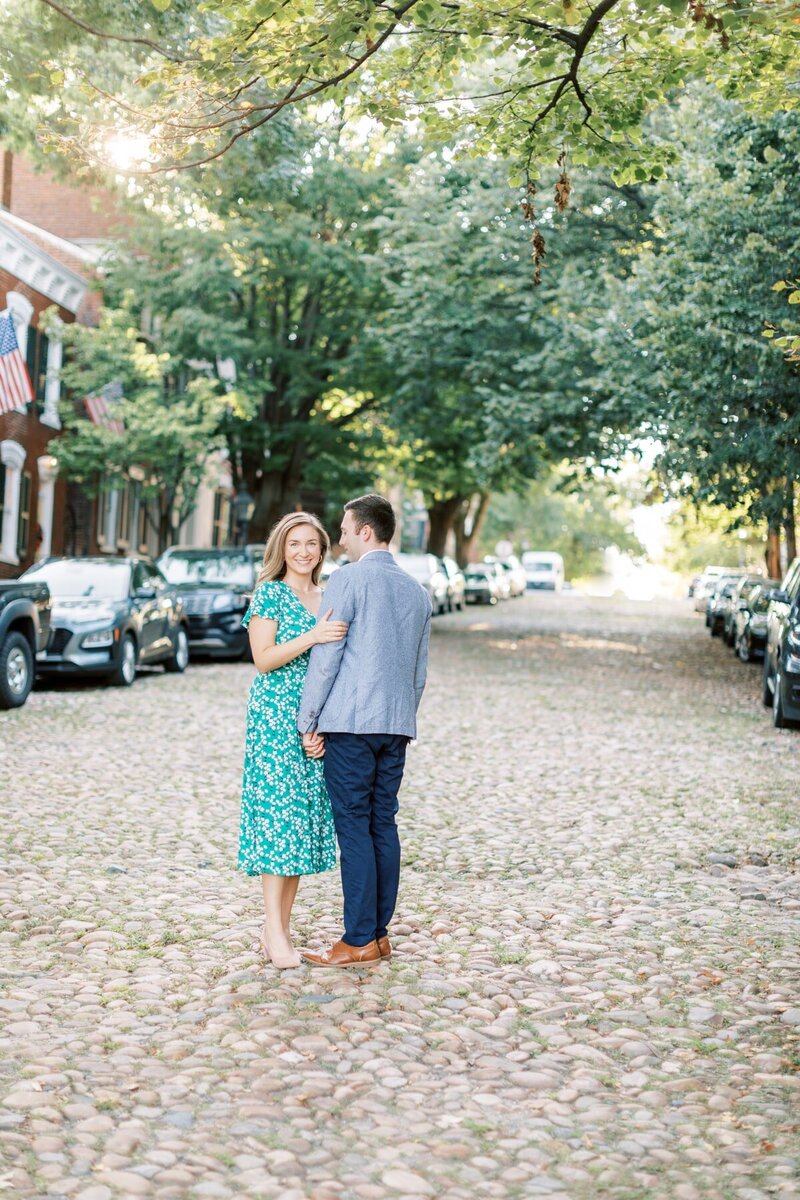 Cute couple hold hands for their engagement session in downtown Alexandria, VA.