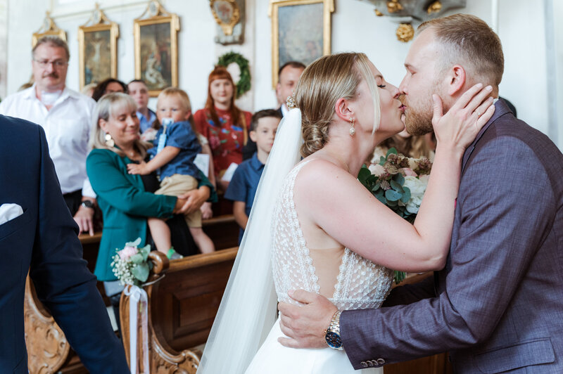 Brautpaar küsst sich nach dem Ja-Wort in der Kirche
