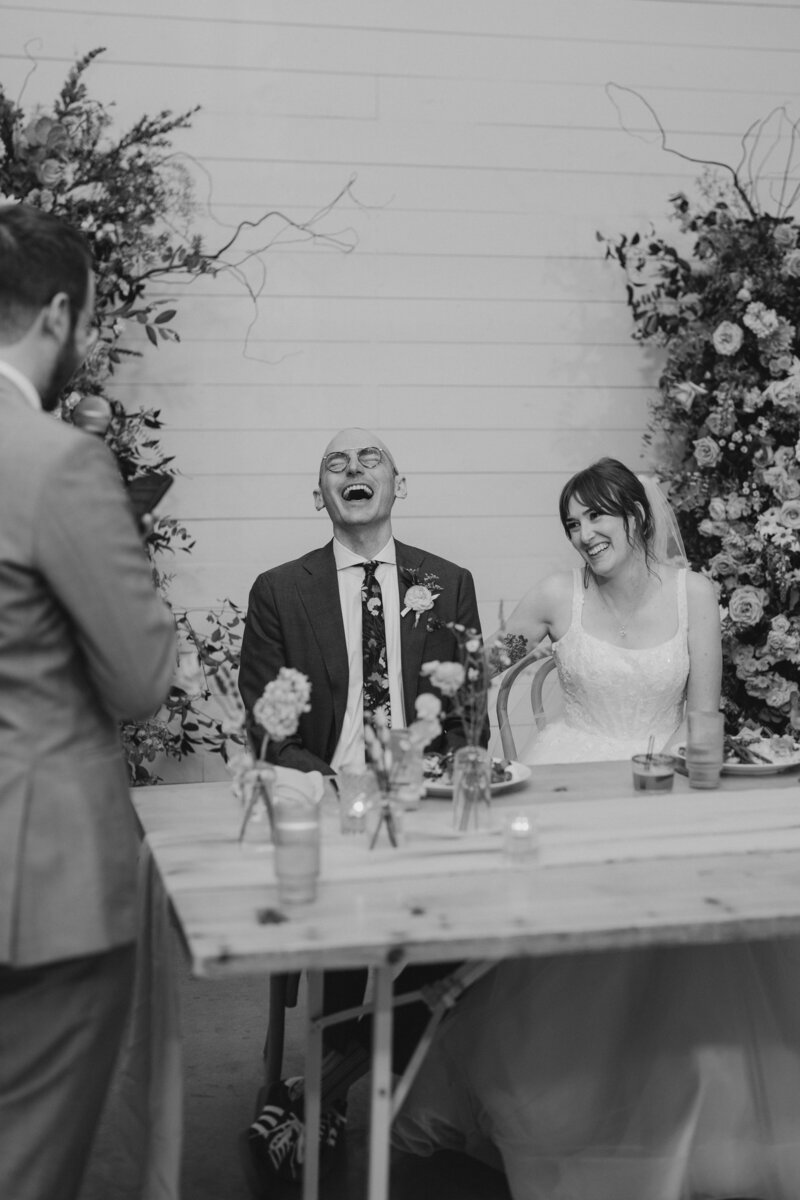 the bride and groom laughed while listening to their best man's speech