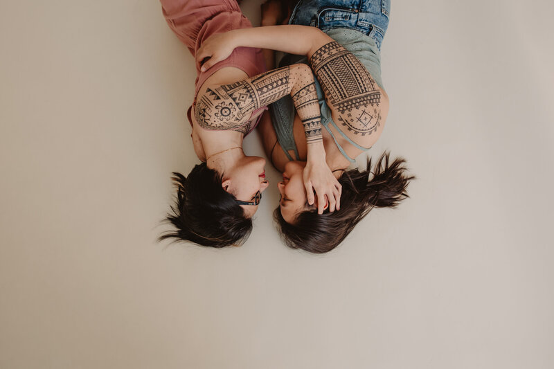 Two people laying down with their arms around each other 