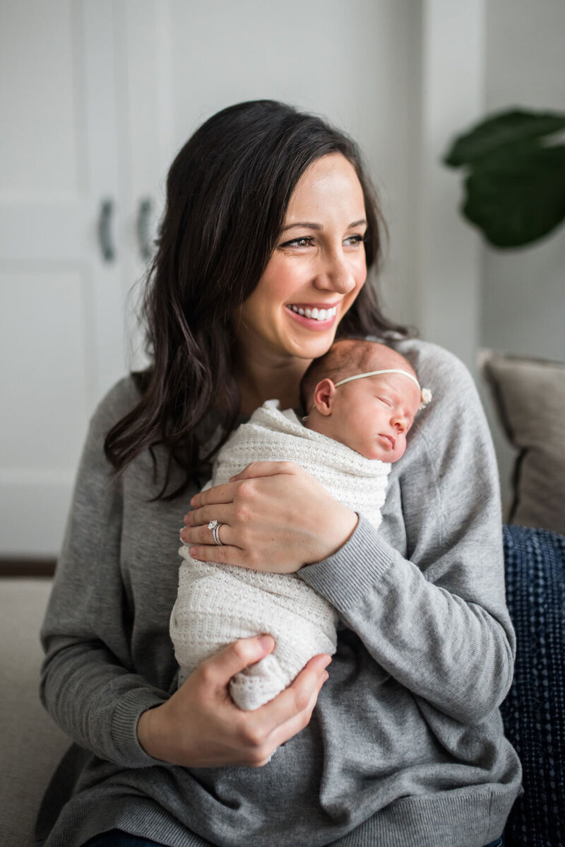 brunette natural mom holding baby in swaddle