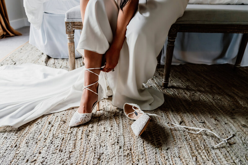 a bride putting on her shoes, close up of the shoes