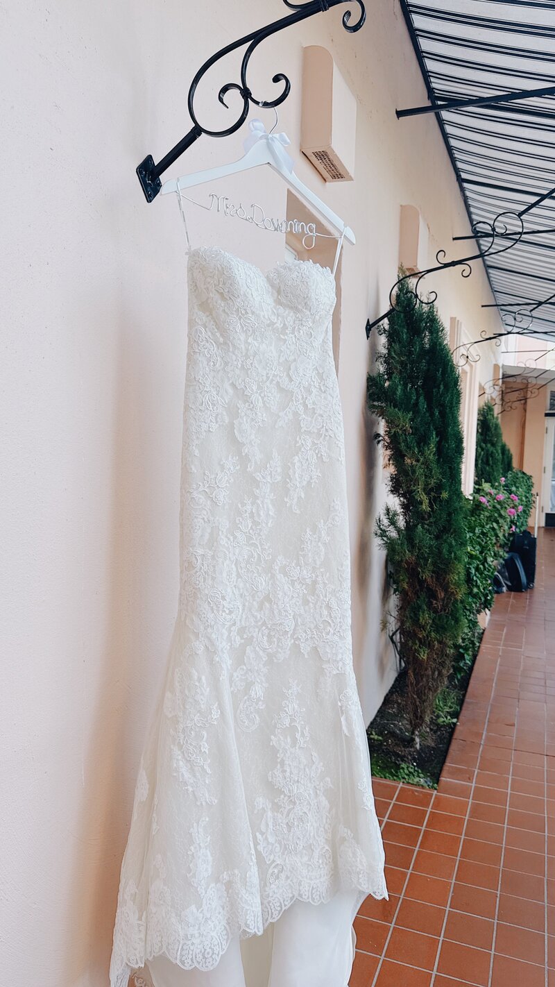 Strapless, lace, white mermaid ballgown handing from an awning at La Jolla's La Valencia Hotel.