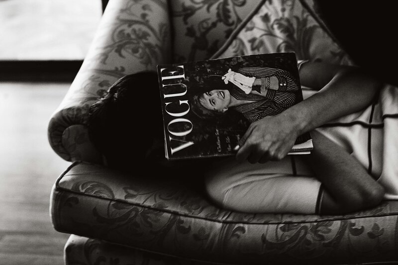 Woman laying on couch with Vogue magazine covering face