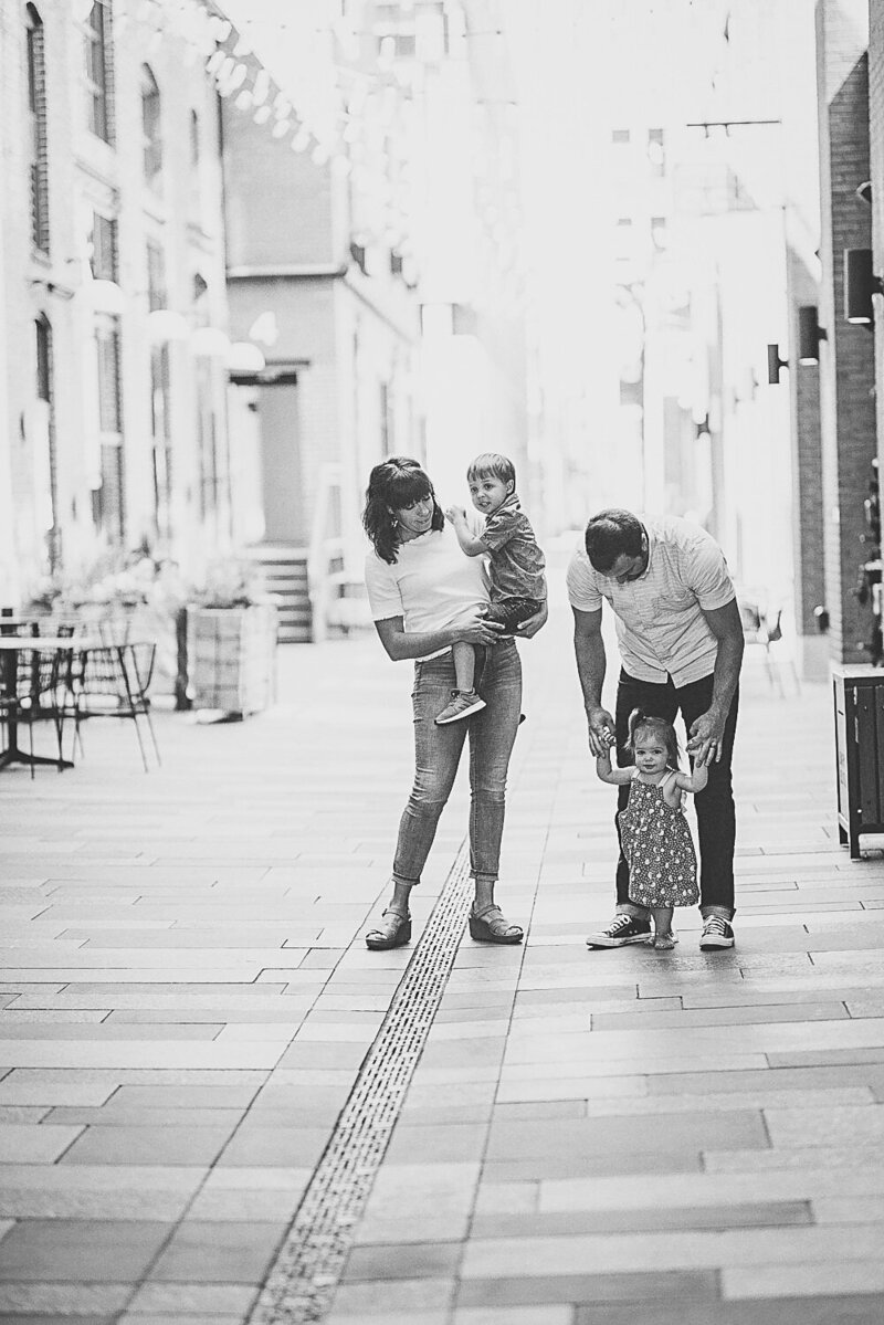 black and white image family walking on sidewalk