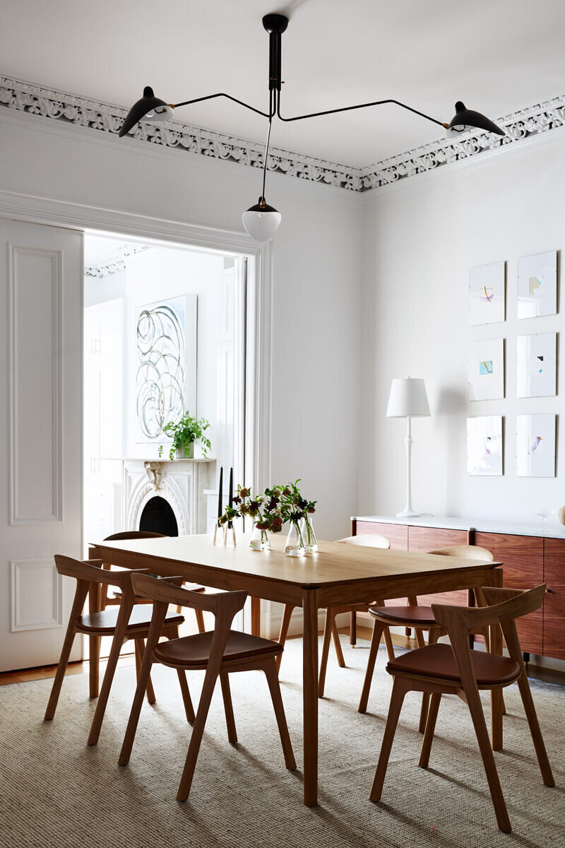 A Boston brownstone’s dining room blends historic details with modern furniture, creating a refined and inviting space.