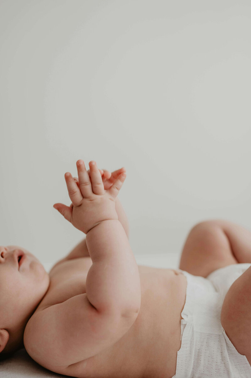 Baby laying down with hands together