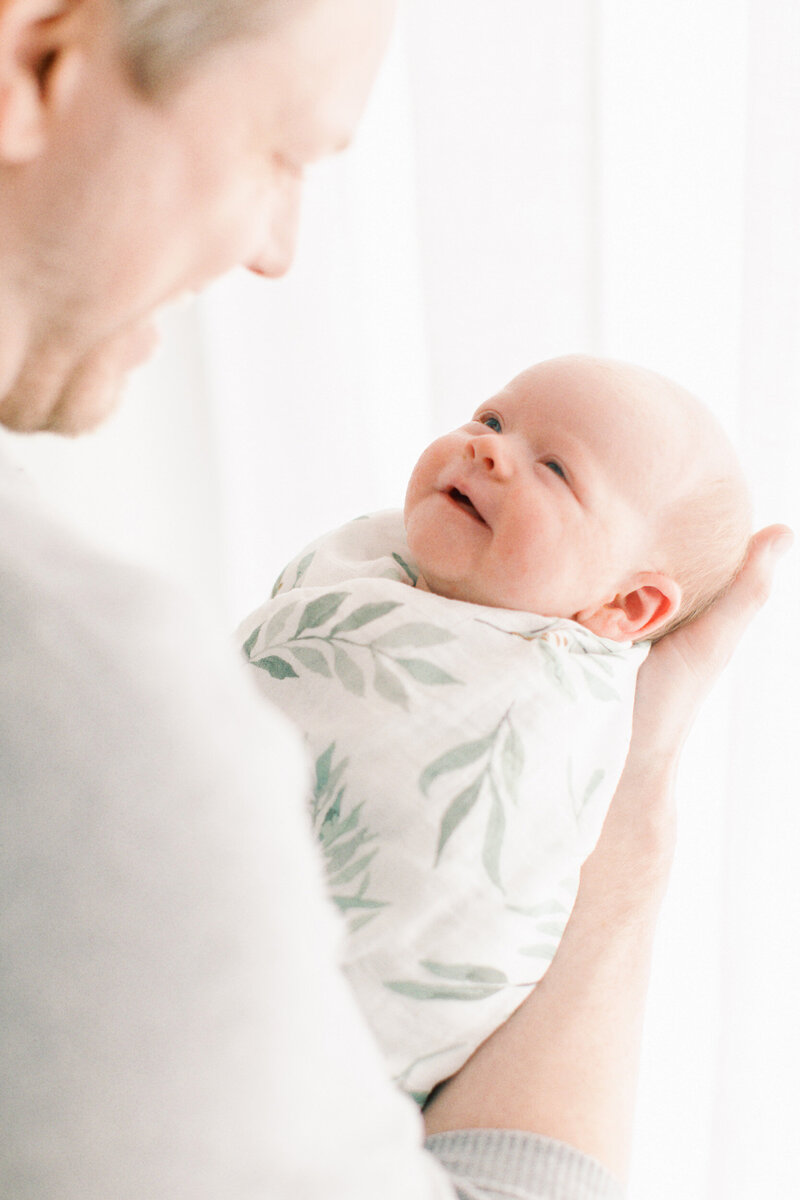 baby smiling at dad by Chicago Newborn Photographer