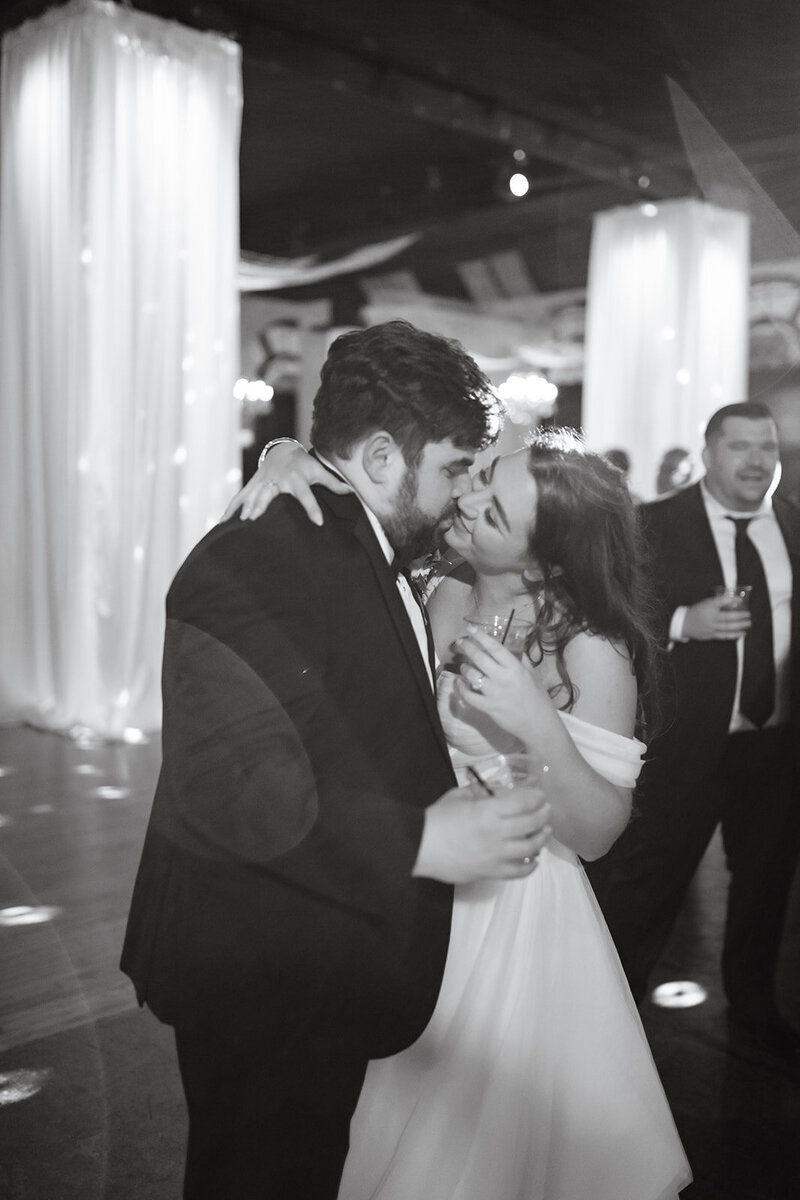 Bride and groom sharing a kiss on the dancefloor of their indoor reception in Winston-Salem