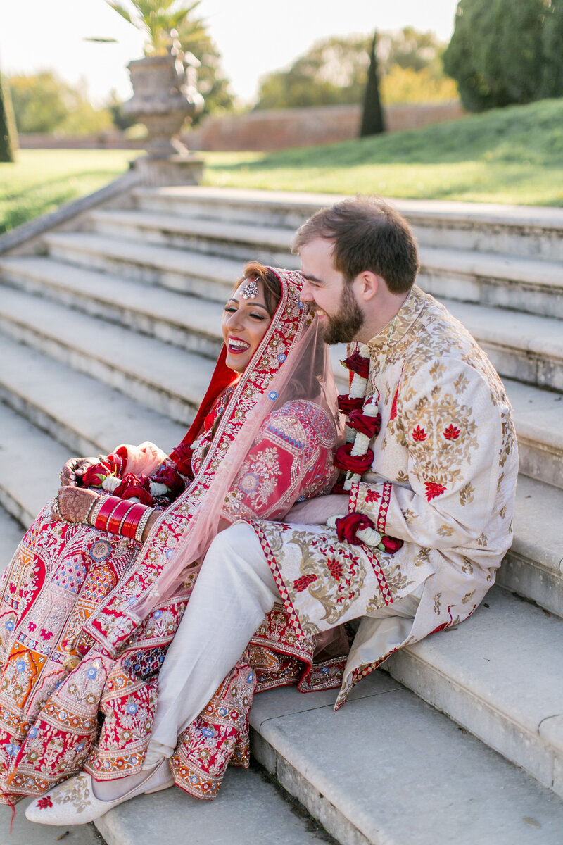 Indian wedding couple smiling on the steps at Hampton Court Palace