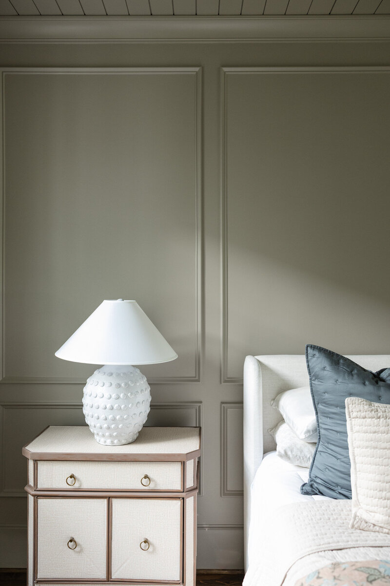 Cozy and elegant bedroom design in Roswell, Georgia with layered textiles, neutral tones, and custom furnishings by Megan Paterson Interiors.
