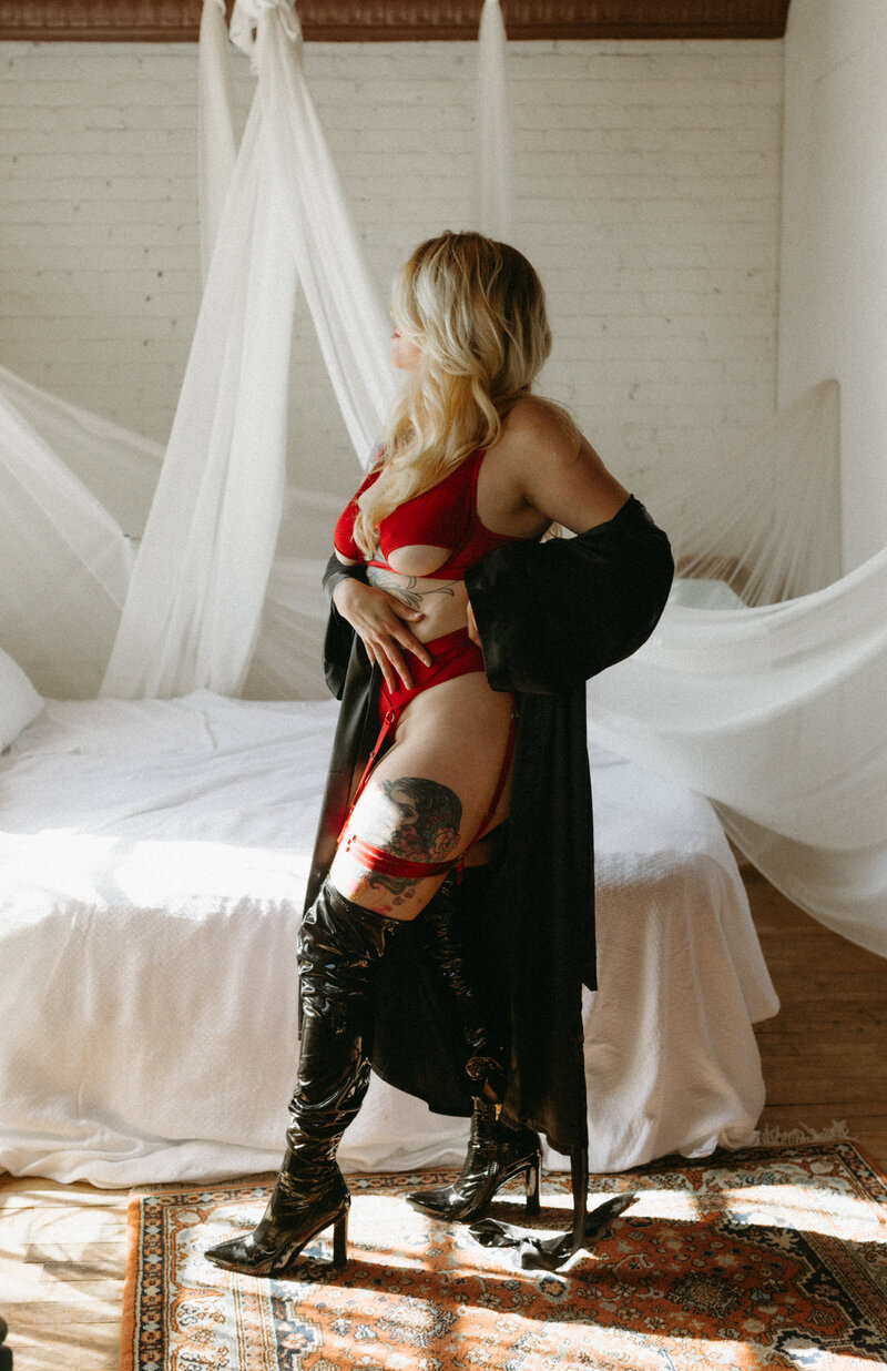 Blonde model in red lingerie and black knee high boots