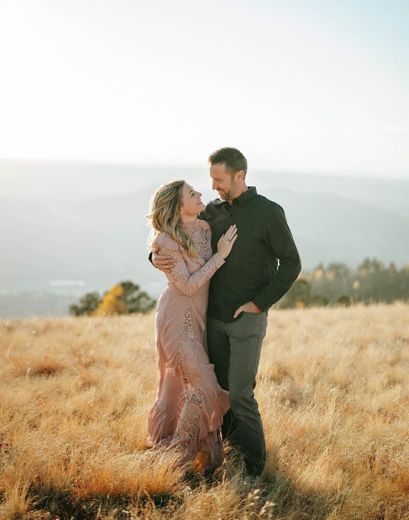 Wife and husband looking at each other close and smiling. Colorado premier location with mountains