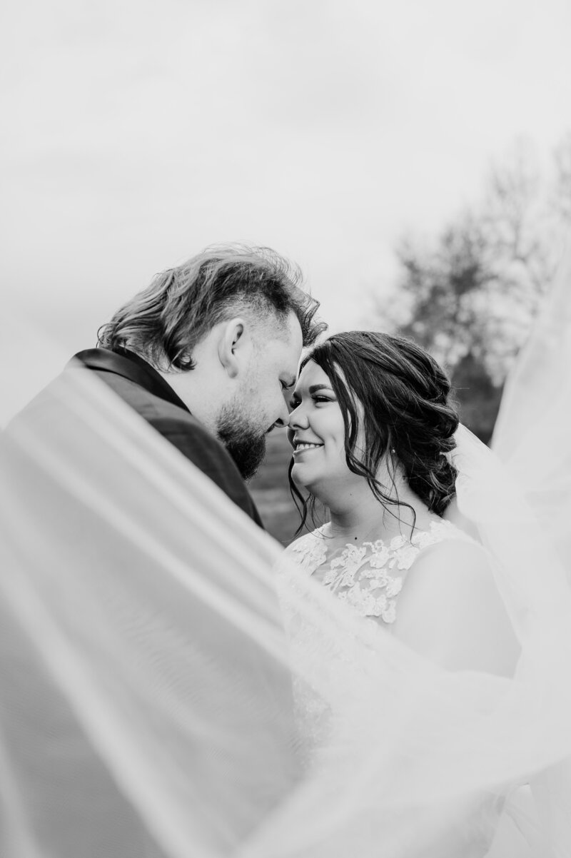 black and white veil shot with bride and groom smiling at each other